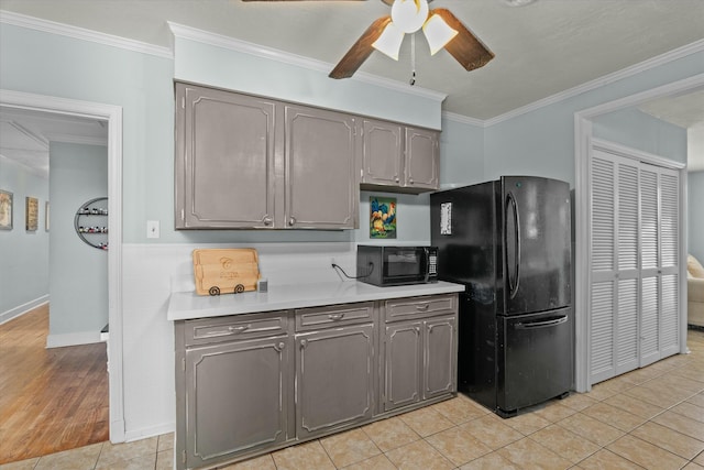 kitchen with a ceiling fan, gray cabinets, ornamental molding, black appliances, and light countertops