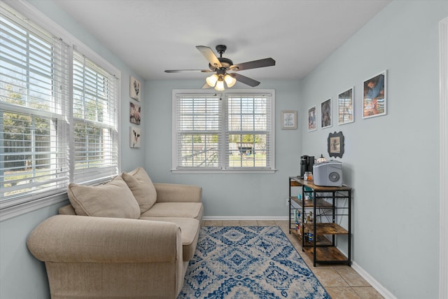 sitting room with light tile patterned flooring, baseboards, and ceiling fan