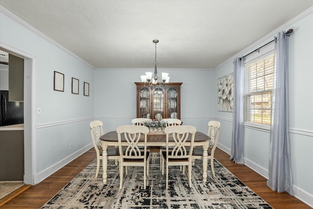 dining room with baseboards, a notable chandelier, dark wood-style floors, and ornamental molding