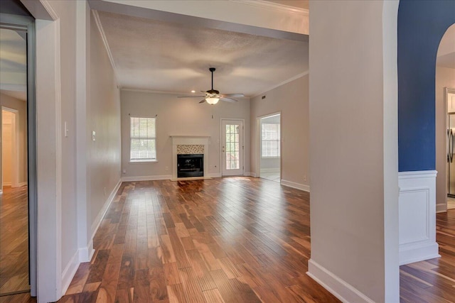 5776 Carriage Hills Dr, Martinez, GA 30907 - unfurnished living room with ornamental molding, a ceiling fan, arched walkways, dark wood finished floors, and a fireplace