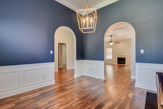 5776 Carriage Hills Dr, Martinez, GA 30907 - spare room with a ceiling fan, a high ceiling, a fireplace, wood finished floors, and a wainscoted wall
