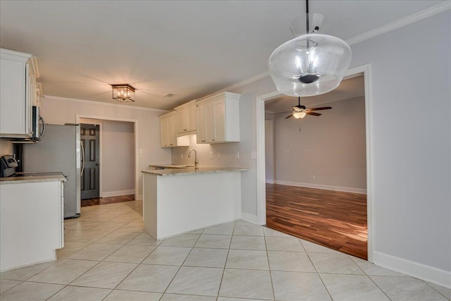 5776 Carriage Hills Dr, Martinez, GA 30907 - kitchen with crown molding, stainless steel microwave, light tile patterned flooring, light stone counters, and a peninsula