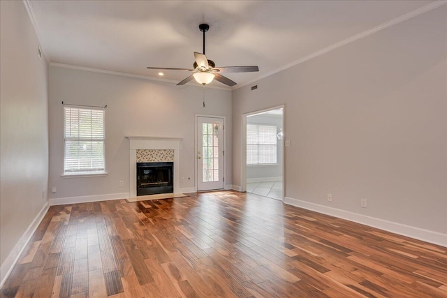 5776 Carriage Hills Dr, Martinez, GA 30907 - unfurnished living room featuring plenty of natural light, a ceiling fan, wood finished floors, crown molding, and a tiled fireplace