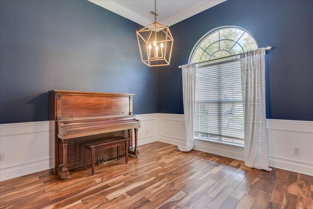 5776 Carriage Hills Dr, Martinez, GA 30907 - living area featuring wainscoting, a chandelier, wood finished floors, crown molding, and a decorative wall