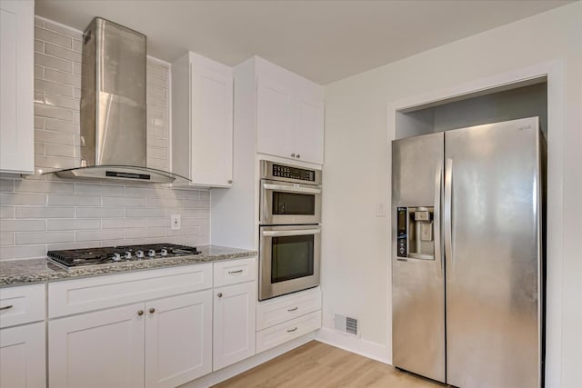 3408 Wheeler Rd, Augusta, GA 30909 - kitchen with appliances with stainless steel finishes, wall chimney range hood, light wood-type flooring, and white cabinets