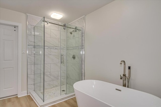 3408 Wheeler Rd, Augusta, GA 30909 - full bath featuring a freestanding tub, a shower stall, and wood finished floors