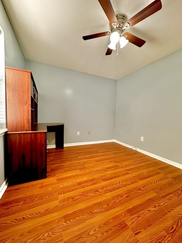 empty room with wood-type flooring and a textured ceiling