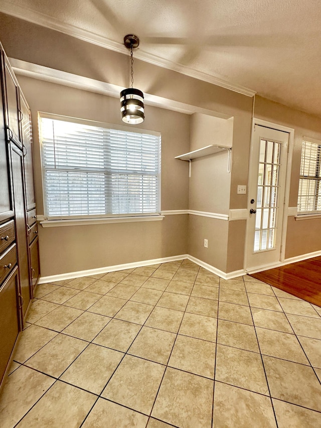 kitchen featuring tasteful backsplash, a textured ceiling, light tile patterned floors, black appliances, and ornamental molding