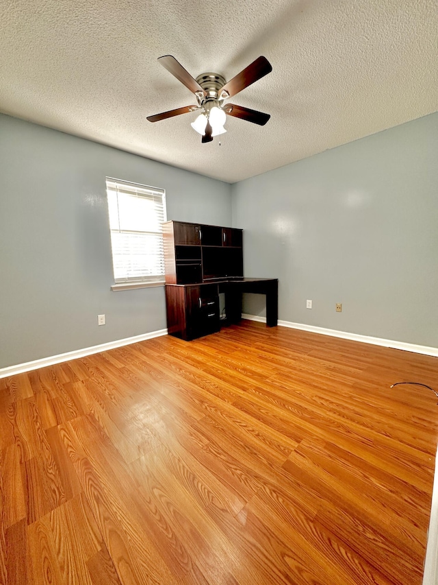 interior space with ceiling fan, light hardwood / wood-style floors, and a textured ceiling