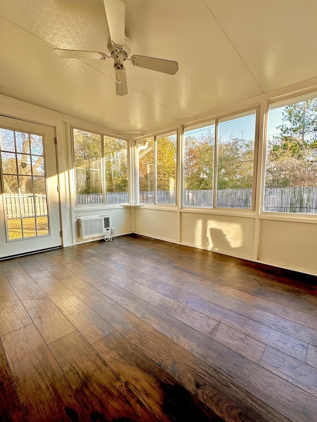 unfurnished sunroom with a wall unit AC and ceiling fan