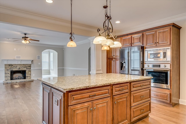 514 Hardwick Ct, Evans, GA 30809 - kitchen featuring stainless steel appliances, arched walkways, a ceiling fan, light stone counters, and brown cabinets