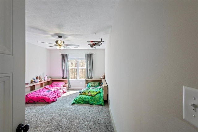 playroom featuring carpet, ceiling fan, a textured ceiling, and baseboards