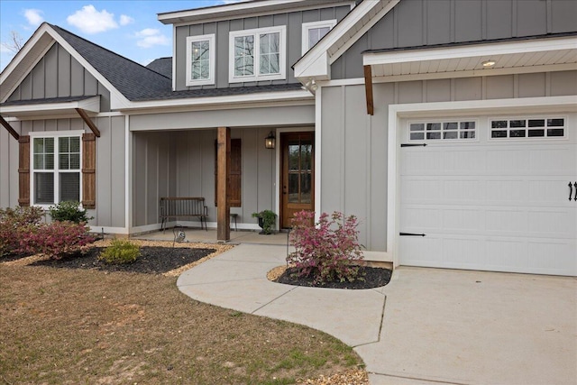 view of exterior entry with covered porch, a shingled roof, board and batten siding, and a garage