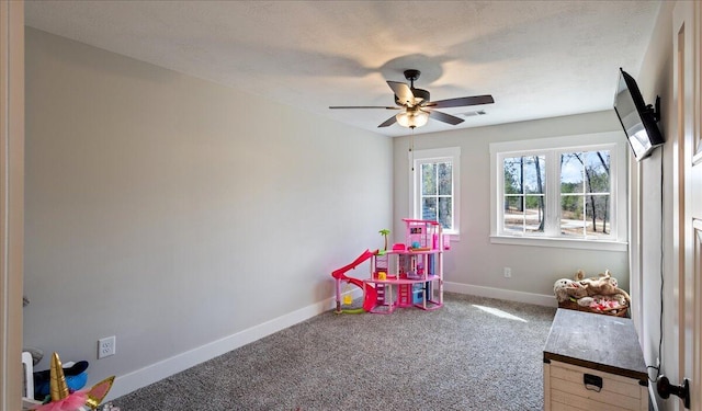 recreation room featuring a ceiling fan, baseboards, visible vents, and carpet flooring