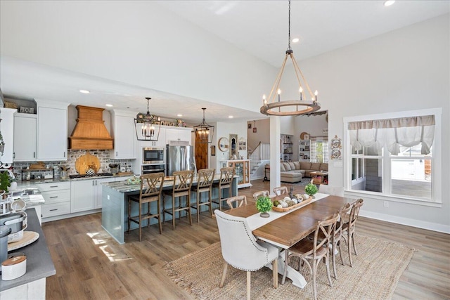 dining space with recessed lighting, wood finished floors, and a notable chandelier