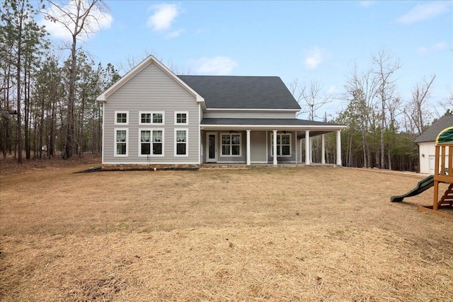 back of property with a yard, a porch, a playground, and a shingled roof