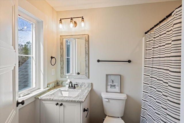 bathroom with a shower with curtain, vanity, and toilet