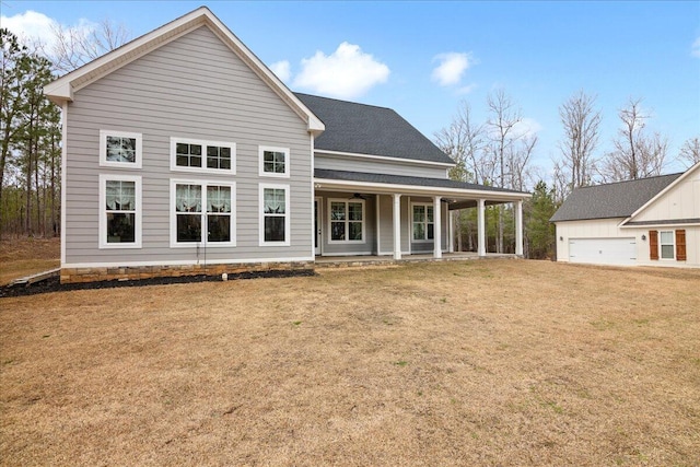 back of property with a porch, a lawn, and a shingled roof