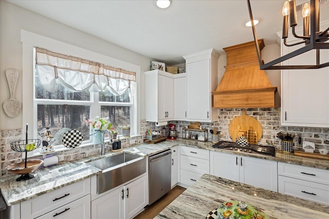 kitchen featuring custom exhaust hood, stainless steel appliances, decorative backsplash, white cabinets, and a sink