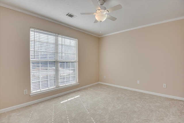 spare room featuring light colored carpet, ceiling fan, and ornamental molding