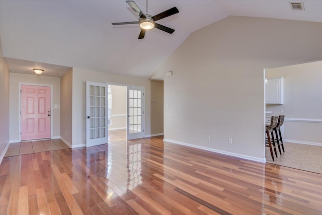 unfurnished living room featuring french doors, light wood-type flooring, ceiling fan, and lofted ceiling