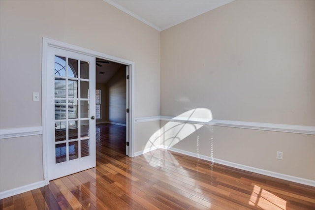 empty room featuring vaulted ceiling, crown molding, hardwood / wood-style floors, and french doors