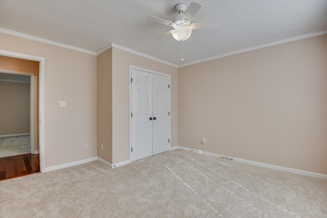 unfurnished bedroom featuring ceiling fan, a closet, light colored carpet, and ornamental molding