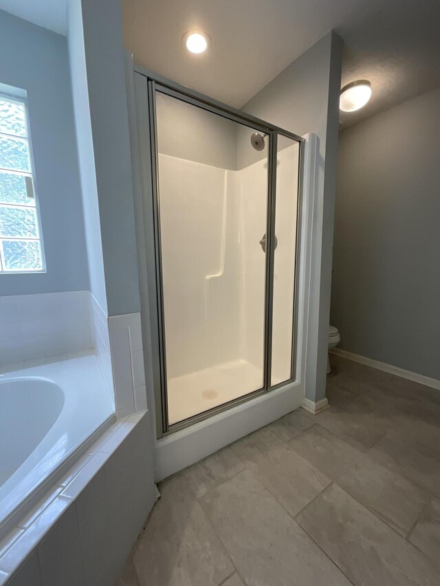 1129 Waltons Trl, Hephzibah, GA 30815 - bathroom featuring a stall shower, a bath, toilet, and baseboards