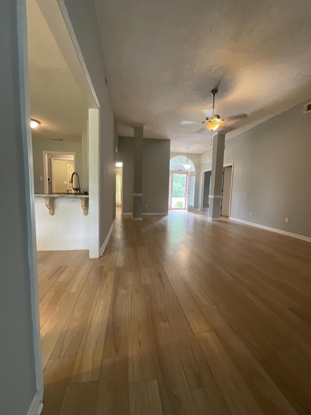 1129 Waltons Trl, Hephzibah, GA 30815 - unfurnished living room with light wood-type flooring, ceiling fan, baseboards, and a textured ceiling