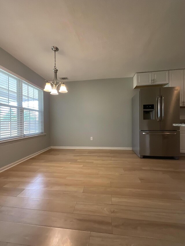 1129 Waltons Trl, Hephzibah, GA 30815 - unfurnished dining area featuring a chandelier, baseboards, and light wood-style floors