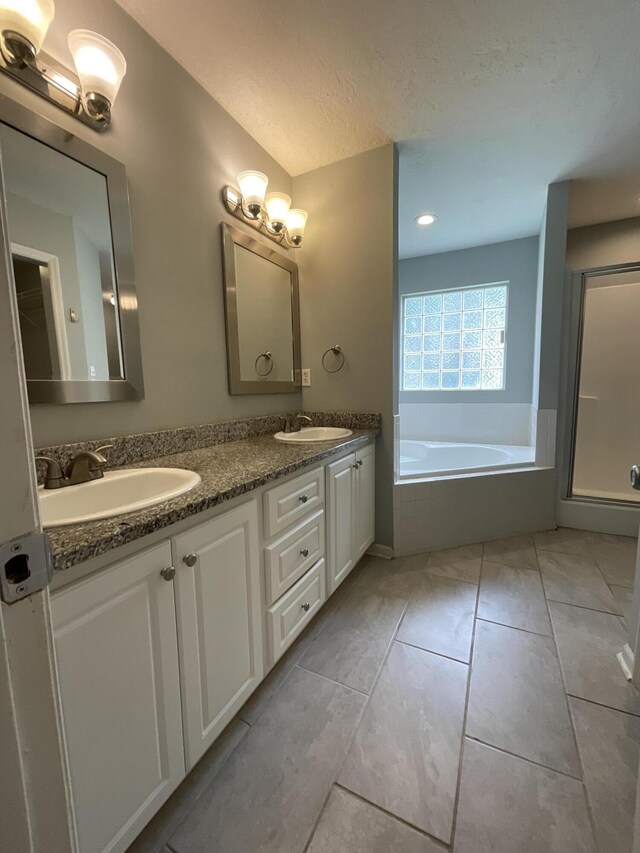 1129 Waltons Trl, Hephzibah, GA 30815 - bathroom with a garden tub, double vanity, an enclosed shower, and a textured ceiling