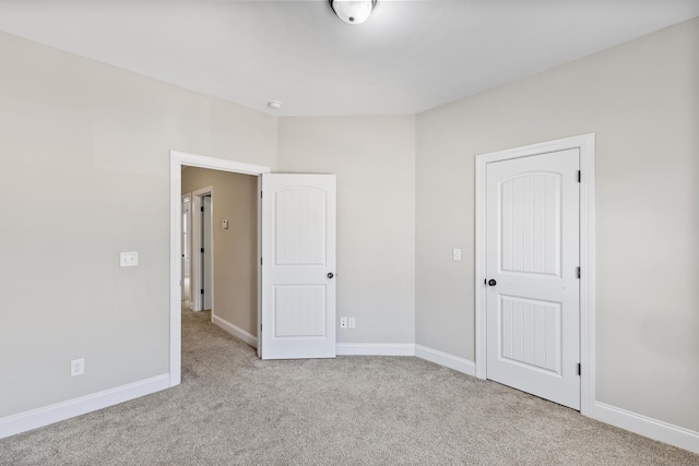 unfurnished bedroom with a closet and light colored carpet