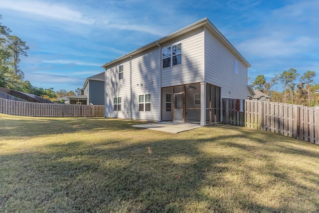 back of house featuring a lawn, a sunroom, and a patio area