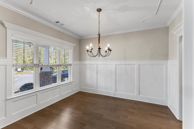 unfurnished dining area featuring ornamental molding, dark wood-type flooring, and a notable chandelier