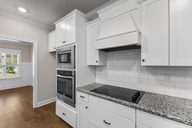 kitchen featuring stone countertops, white cabinetry, custom range hood, and stainless steel appliances