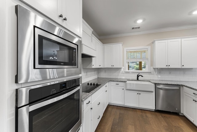 kitchen featuring light stone countertops, stainless steel appliances, white cabinetry, and sink