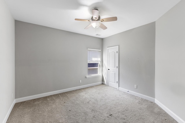 spare room featuring light carpet and ceiling fan