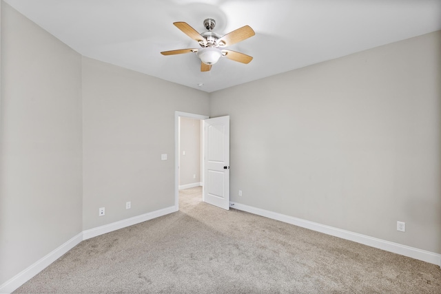 carpeted spare room featuring ceiling fan