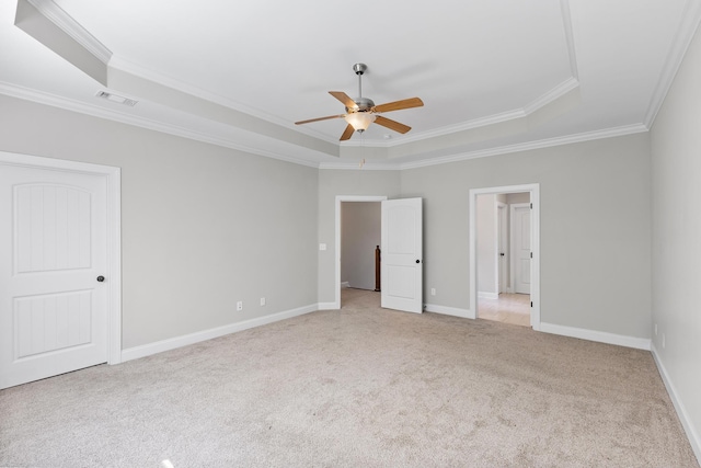 unfurnished bedroom featuring light colored carpet, a raised ceiling, ceiling fan, and crown molding