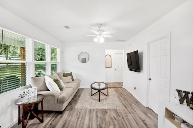 living room with light hardwood / wood-style flooring and ceiling fan