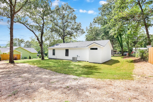 back of house featuring a lawn and central AC