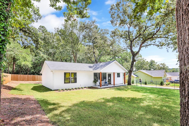 ranch-style house featuring a front lawn and a patio area