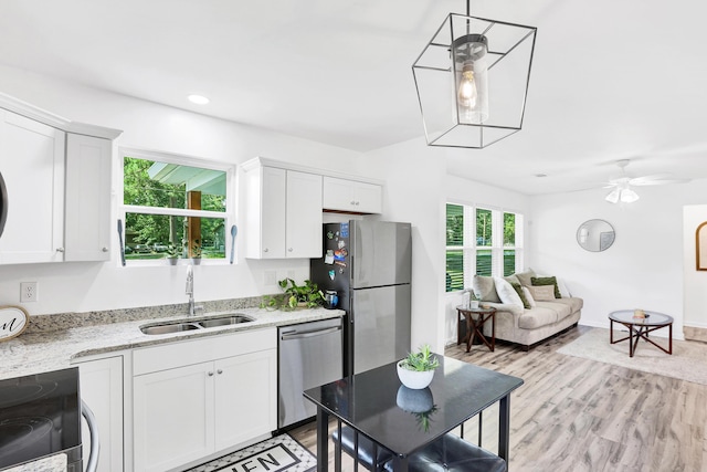 kitchen featuring pendant lighting, white cabinets, sink, ceiling fan, and appliances with stainless steel finishes