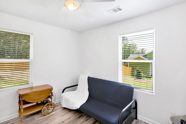 sitting room with light wood-type flooring, plenty of natural light, and ceiling fan