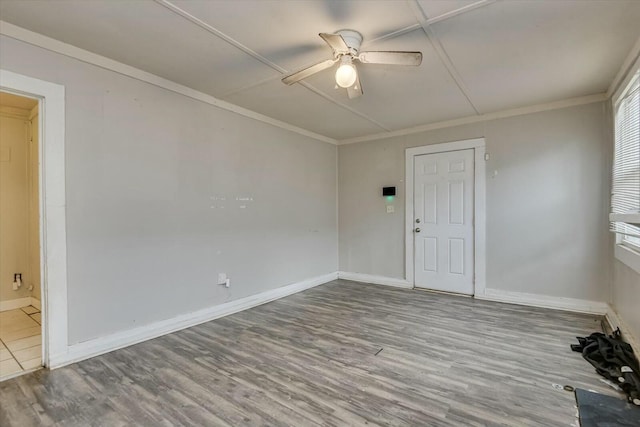 spare room with ceiling fan, plenty of natural light, wood-type flooring, and crown molding