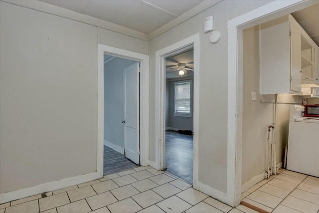 hallway with washer / dryer, light tile patterned floors, and crown molding