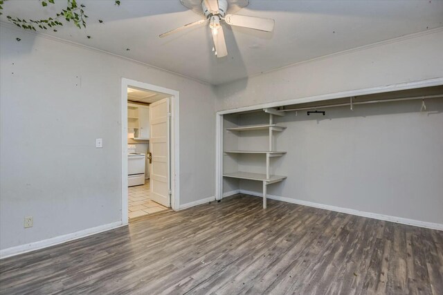 unfurnished bedroom featuring hardwood / wood-style floors, ceiling fan, crown molding, and a closet