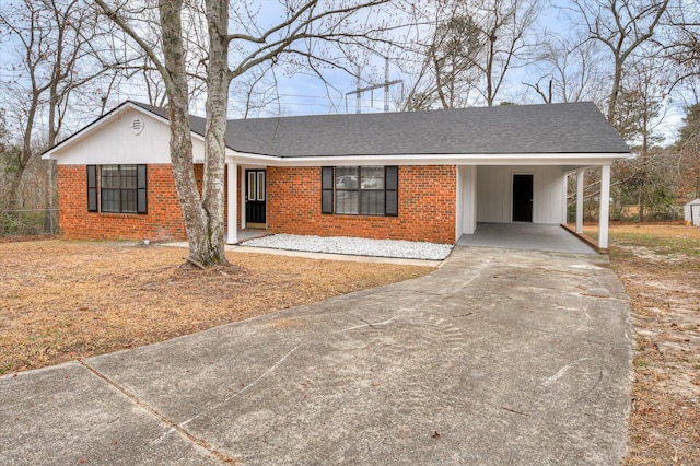 single story home featuring concrete driveway, brick siding, a shingled roof, and an attached carport