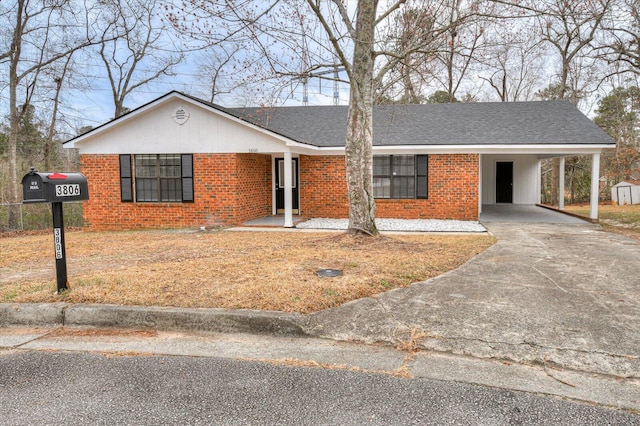 single story home with driveway, roof with shingles, a carport, and brick siding