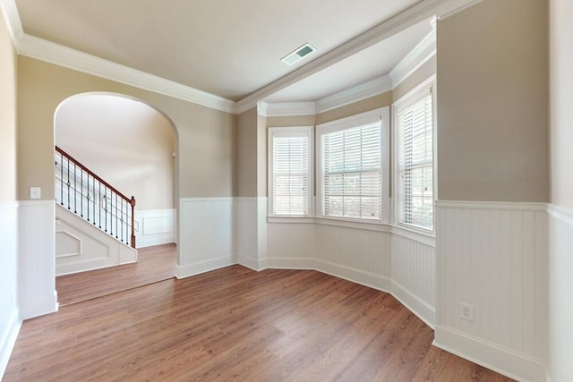 1217 Berkley Hills Pass, Evans, GA 30809 - spare room featuring wainscoting, arched walkways, wood finished floors, stairs, and crown molding
